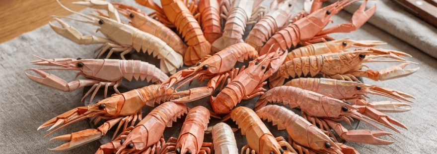 Plate of origami crayfish arranged around a bowl with lemon slices and dipping sauce
