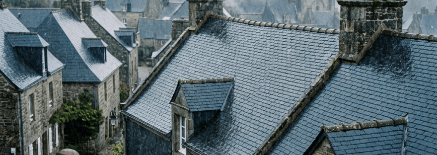 Rainy historic village with slate rooftops and church tower